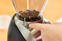 A person adjusts the grind setting on the Baratza Virtuoso+ Conical Burr Coffee Grinder
