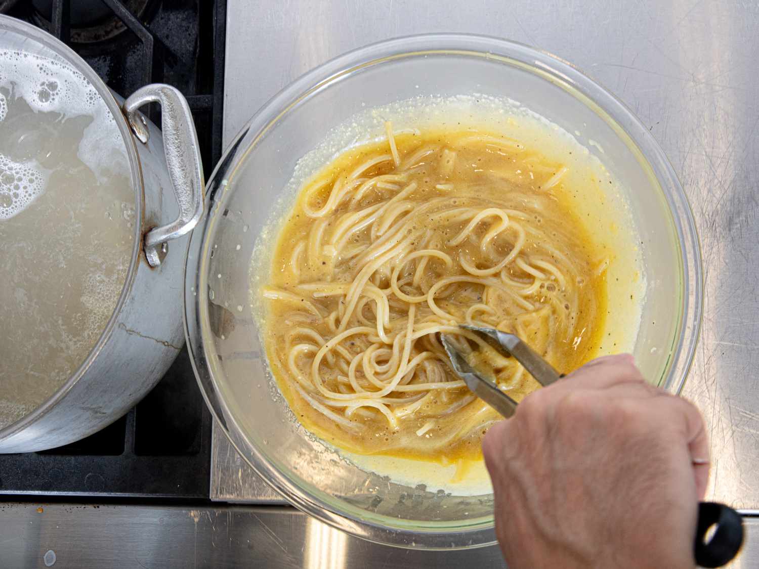 Overhead view of adding spagetti to egg mixture