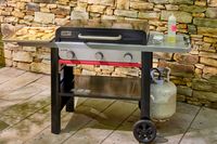 The Weber Slate 28 inch Rust-Resistant 3 Burner Outdoor Griddle on a patio