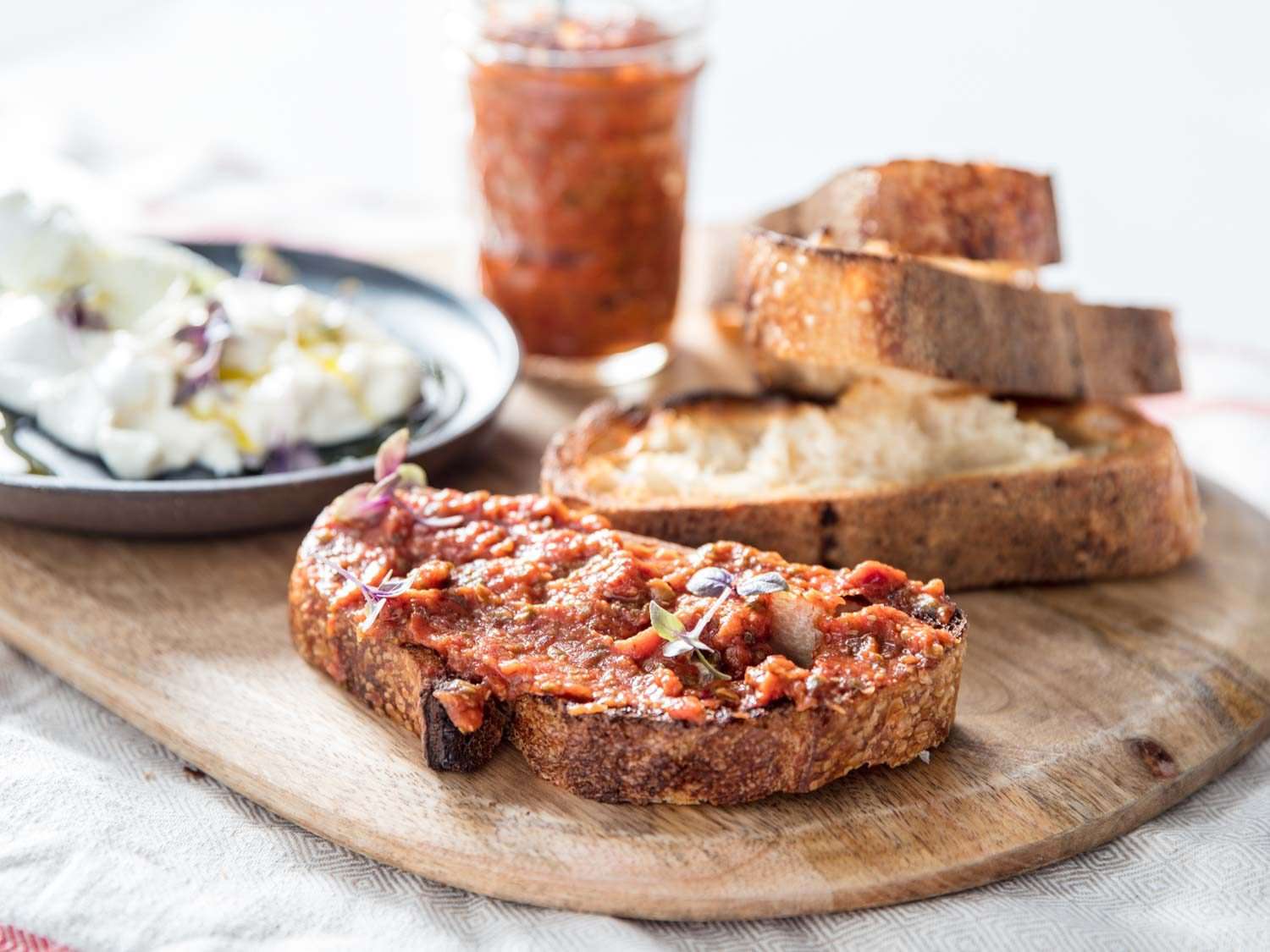 Finished tomato and caper spread on toast with burrata.