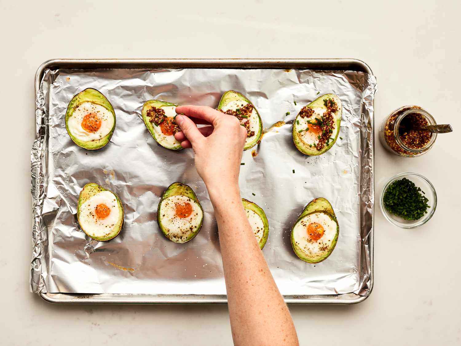 Overhead view of adding mustard to backed eggs