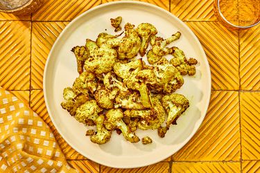 Overhead view of airfryer cauliflower on an orange table setting