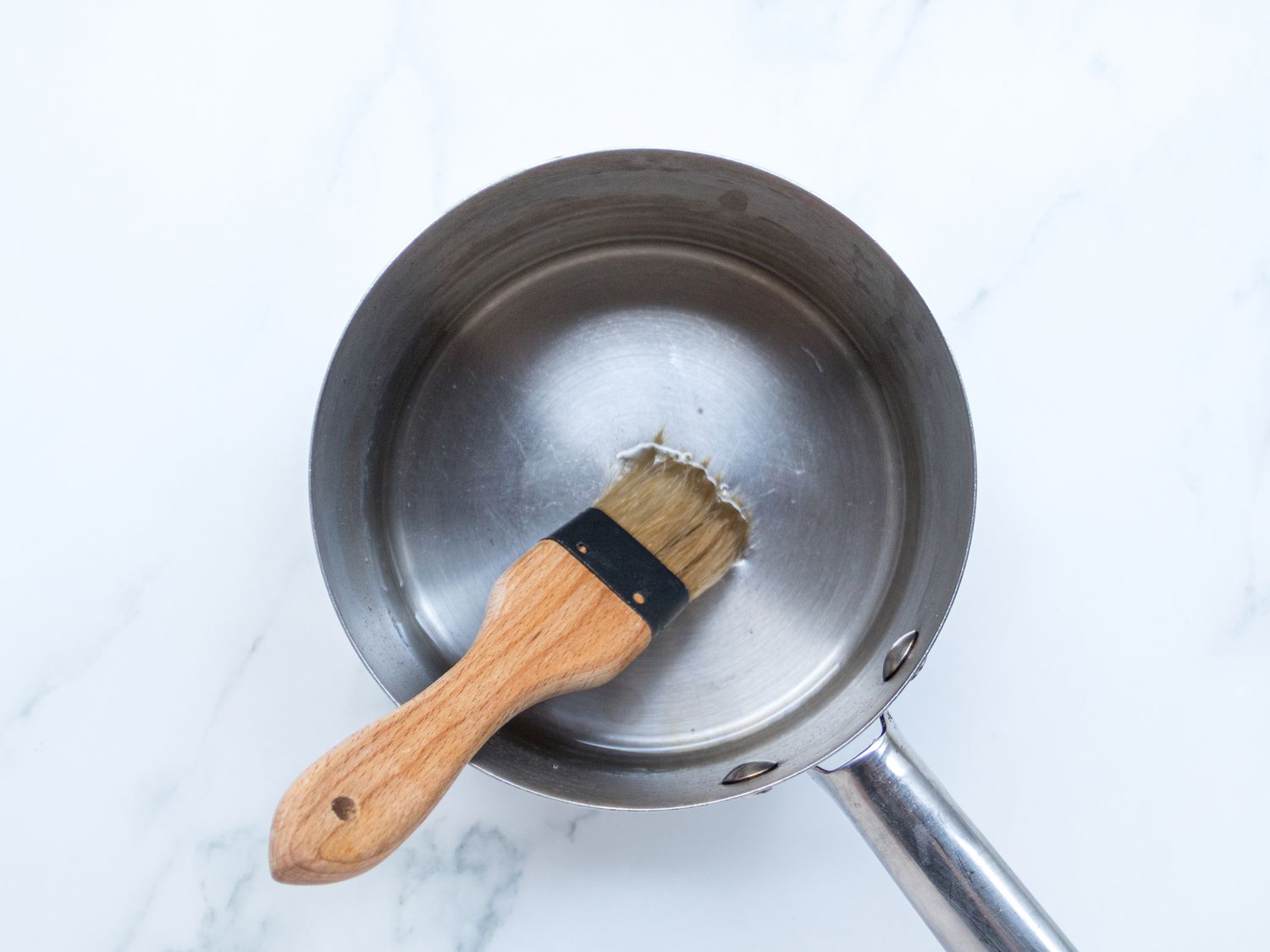 Simple syrup in a saucepan with a brush in it