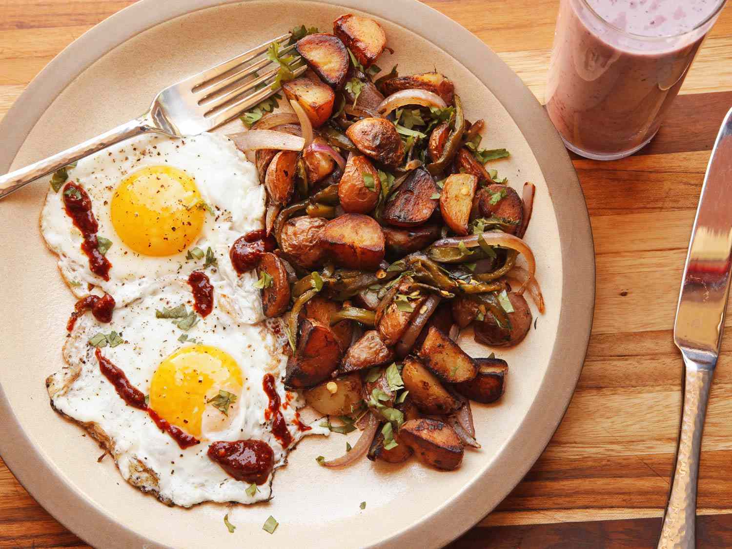 Overhead shot of breakfast plate with two fried eggs and pile of hash browns