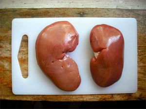 Overhead view of two kidneys on a cutting board.