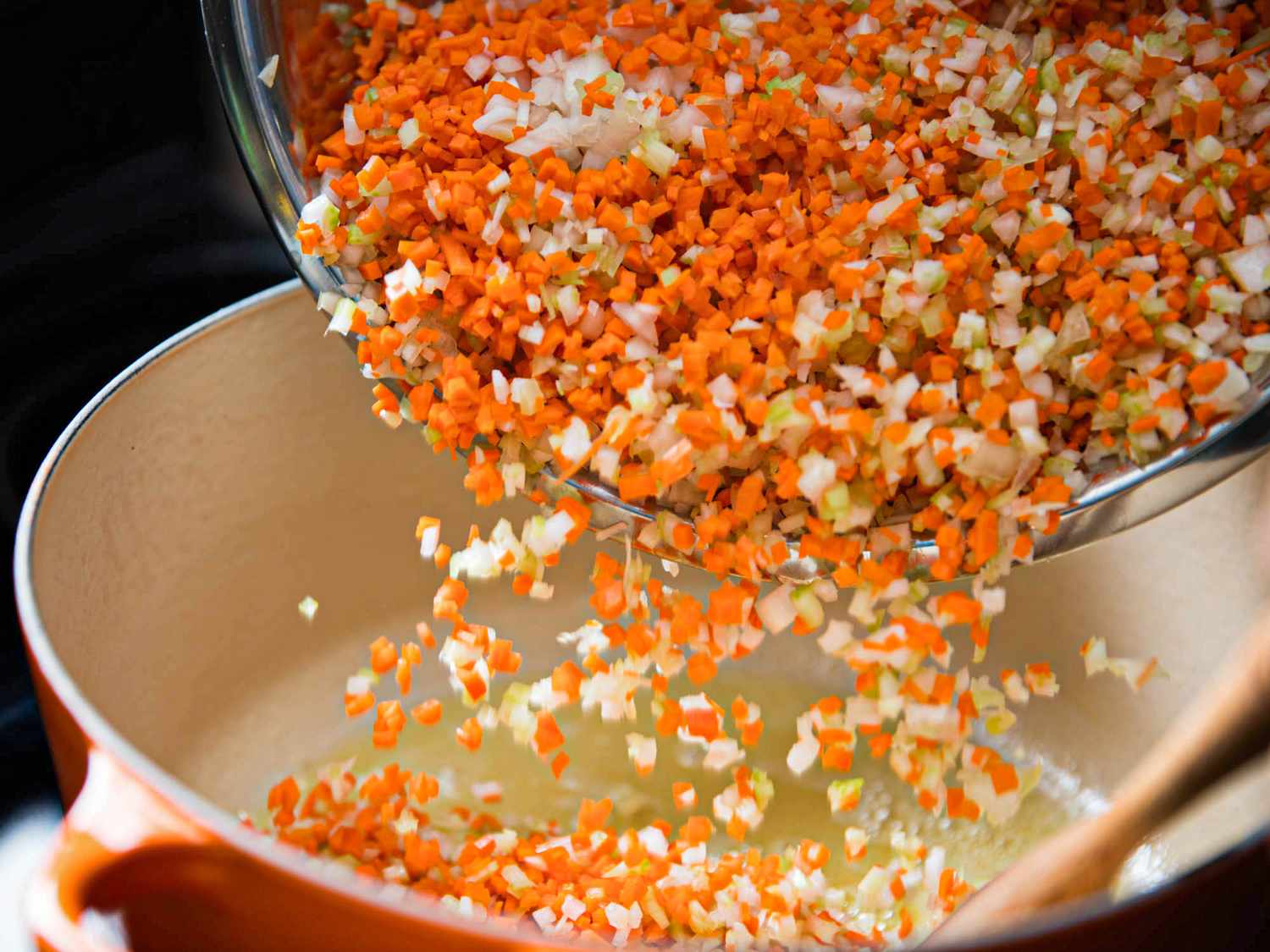 Diced vegetables being added to a pot