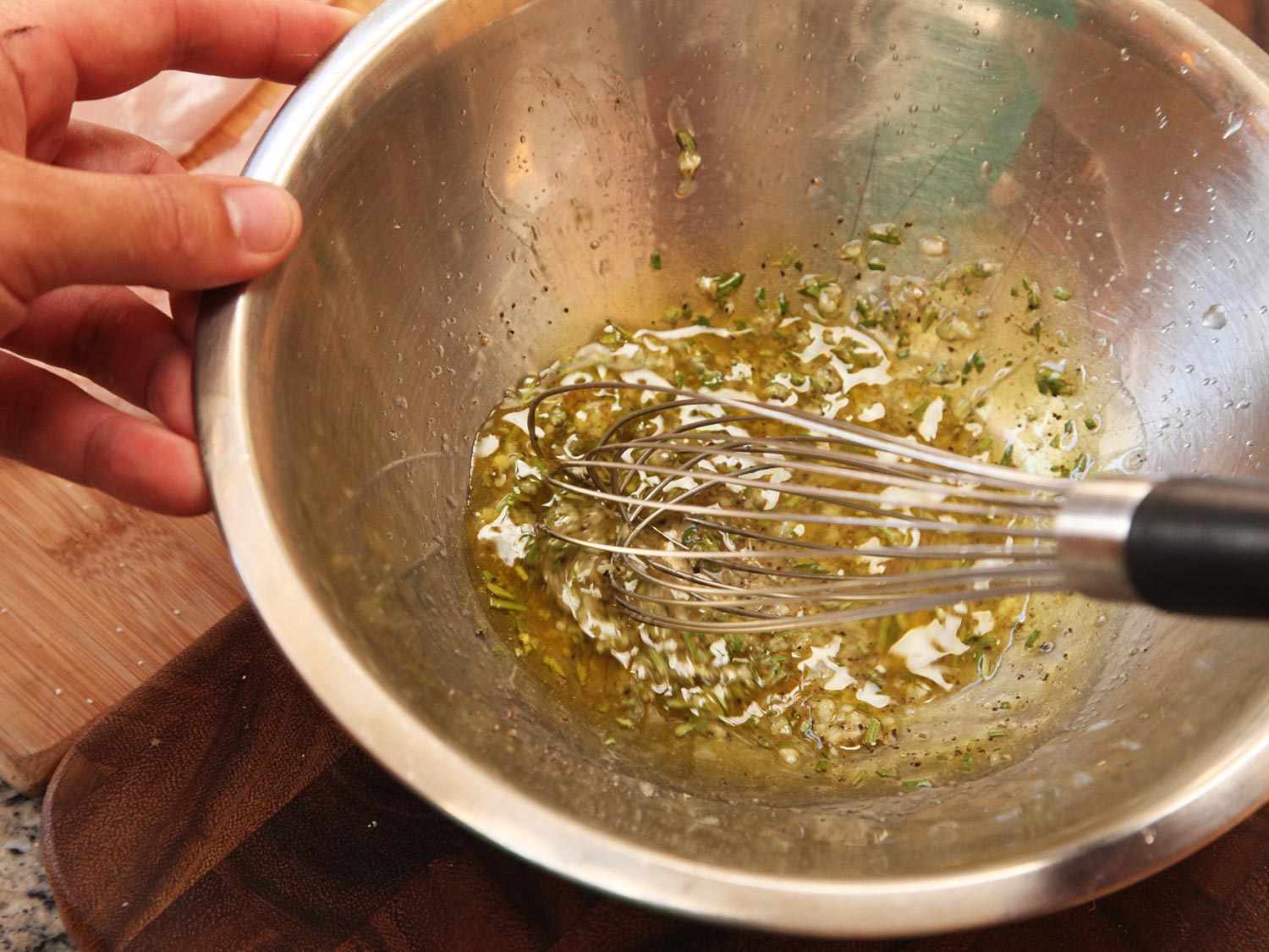 Whisking together vinaigrette/marinade in a metal bowl.