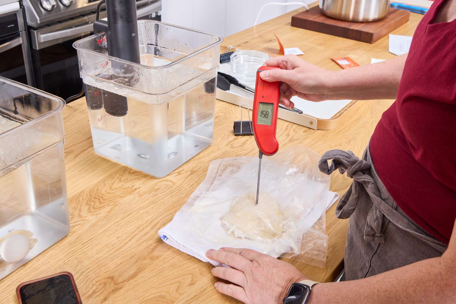 A person takes the temperature of meat cooked using the Anova Culinary Sous Vide Precision Cooker Nano 3.0