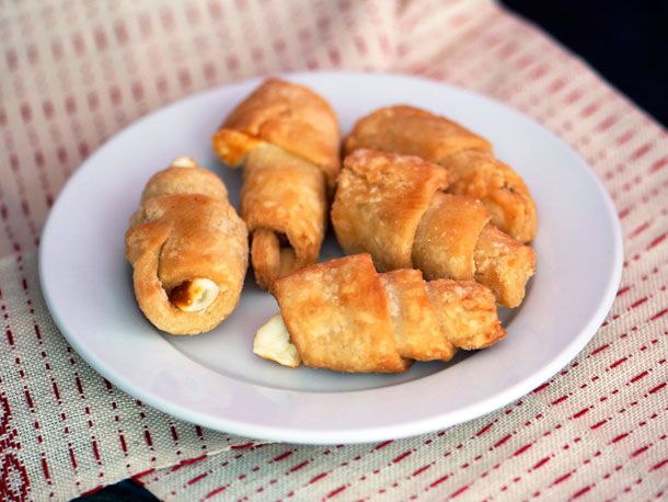 A small plate loaded with 5 churros de queso.