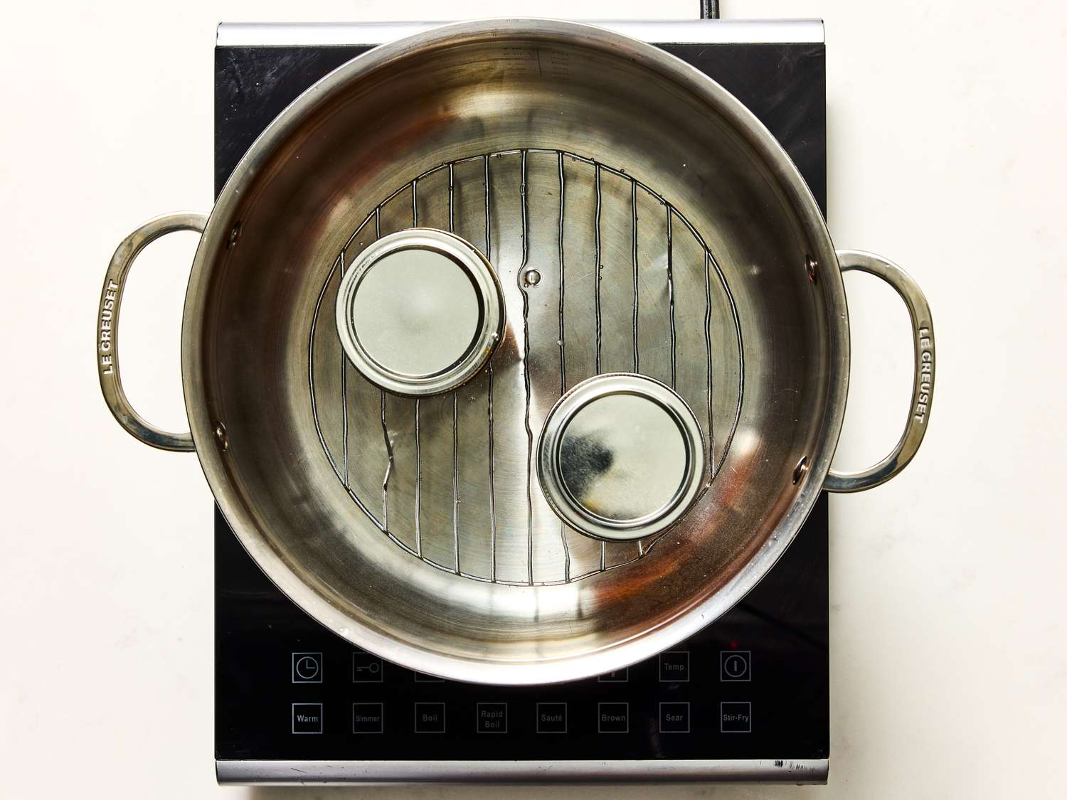 Cooking setup with jars in a pot for a canning process