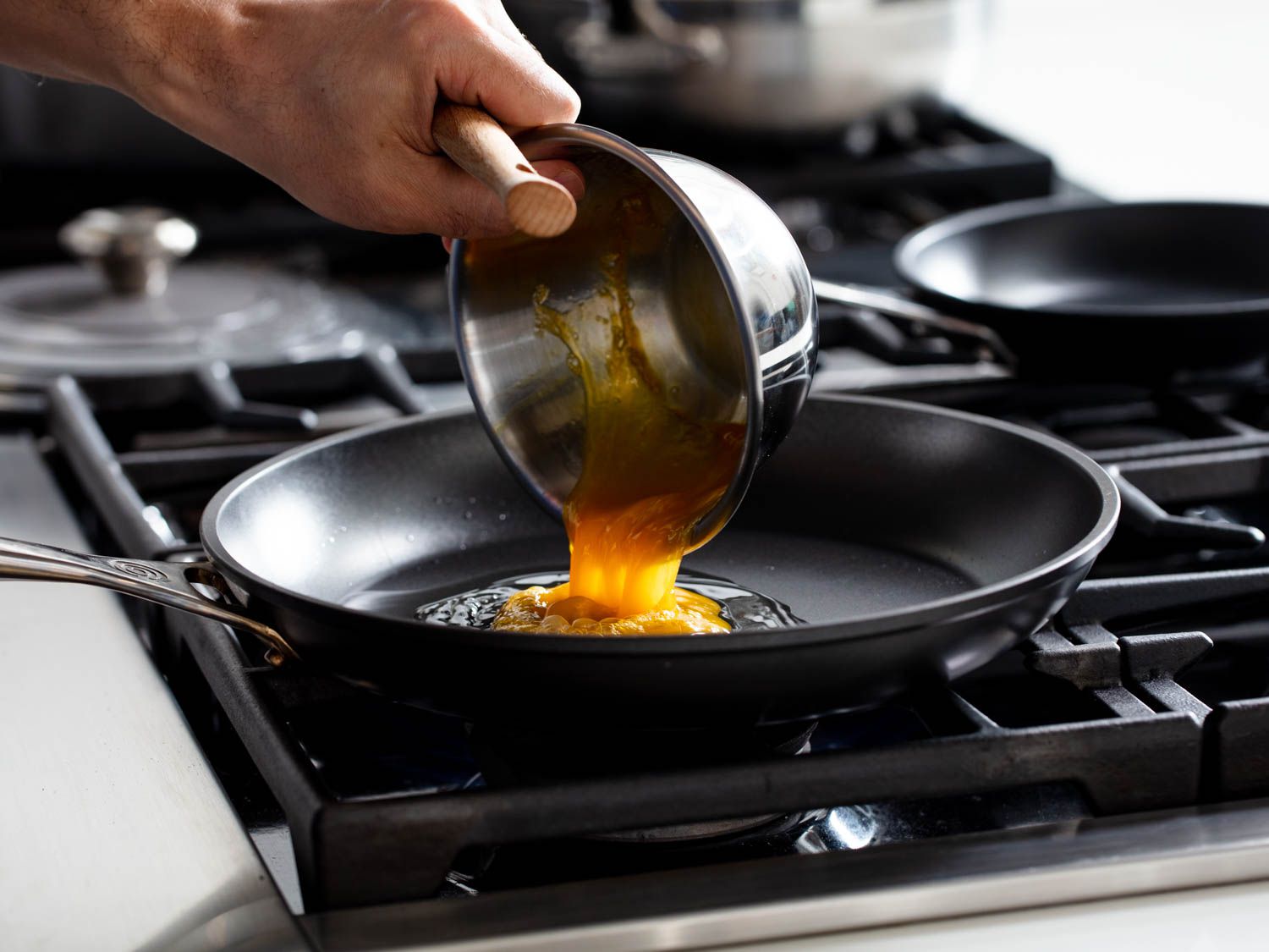 Beaten egg is added to a non-stick skillet.