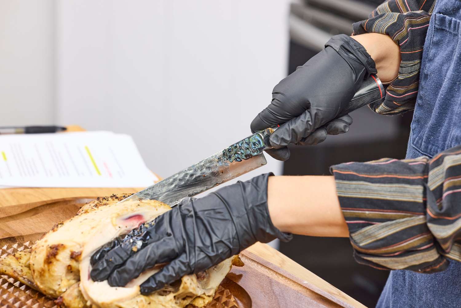 A person cuts chicken with the Miyabi Mizu SG2 9.5 Inch Slicing Knife