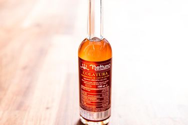 Closeup of a bottle of aged Italian fish sauce called colatura.