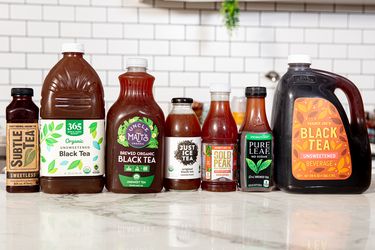 A selection of bottled and jugged black teas displayed on a counter