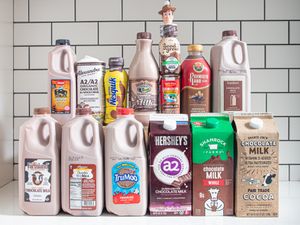 A variety of chocolate milk brands displayed on a counter including cartons and bottles