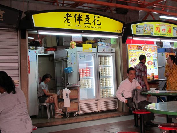 A stall at a Singaporean food court with a two cold cases full of soya beancurd.