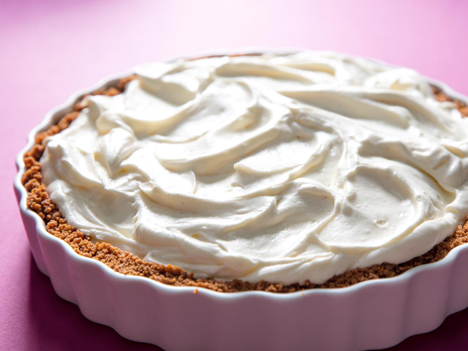 The Biscoff crust, filled with the cheesecake mixture. The irregular surface of the filling is backlit, and suggestive of a mountainous snow-covered landscape.