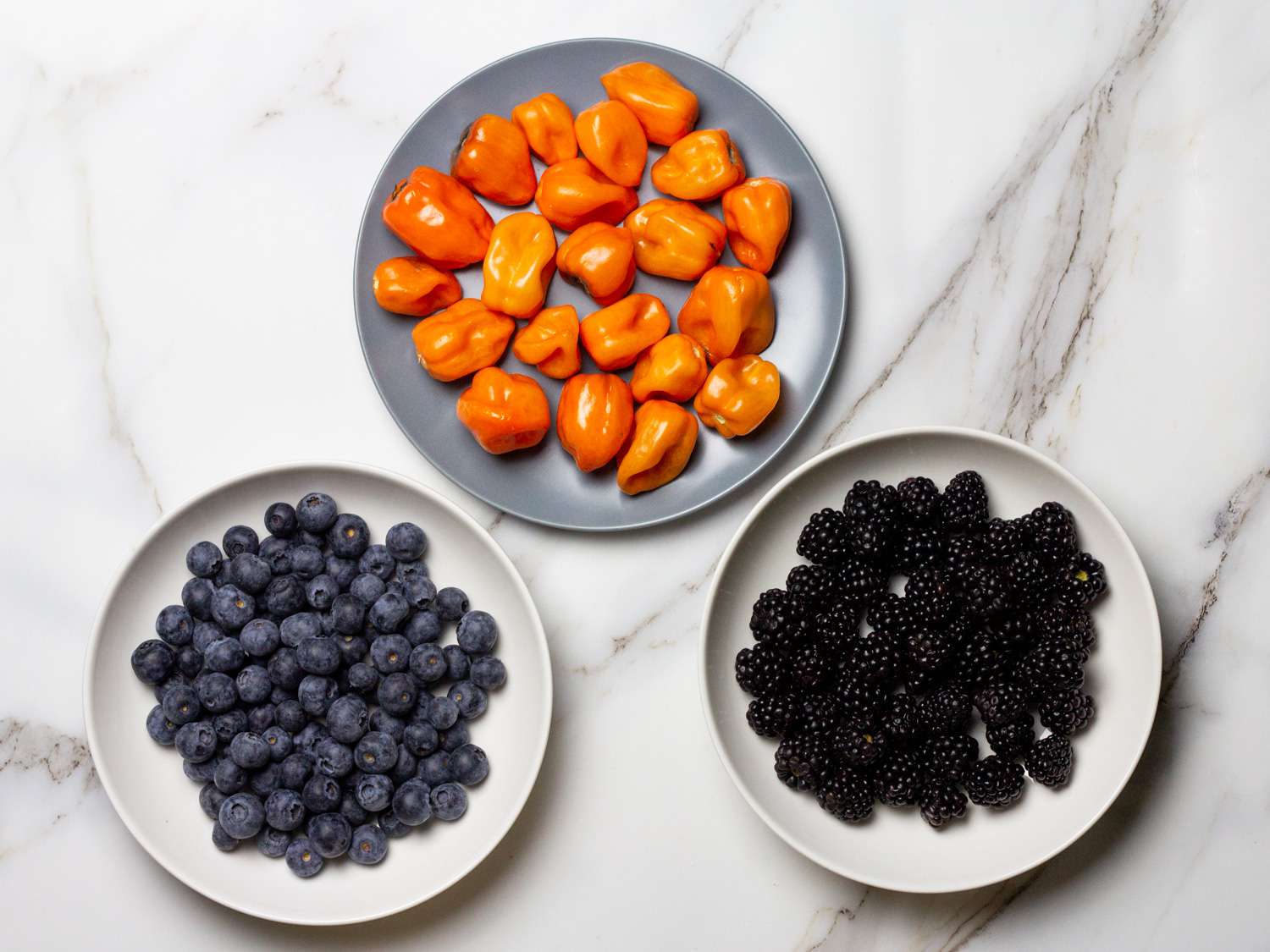 Plates of berries and habanero peppers to be made into hot sauce.