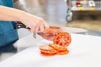 Hands slicing a tomato with a Misono UX10 8.2-Inch Gyutou