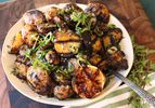 Overhead view of grilled-potato salad with grilled-lemon vinaigrette, mounded on a white plate.