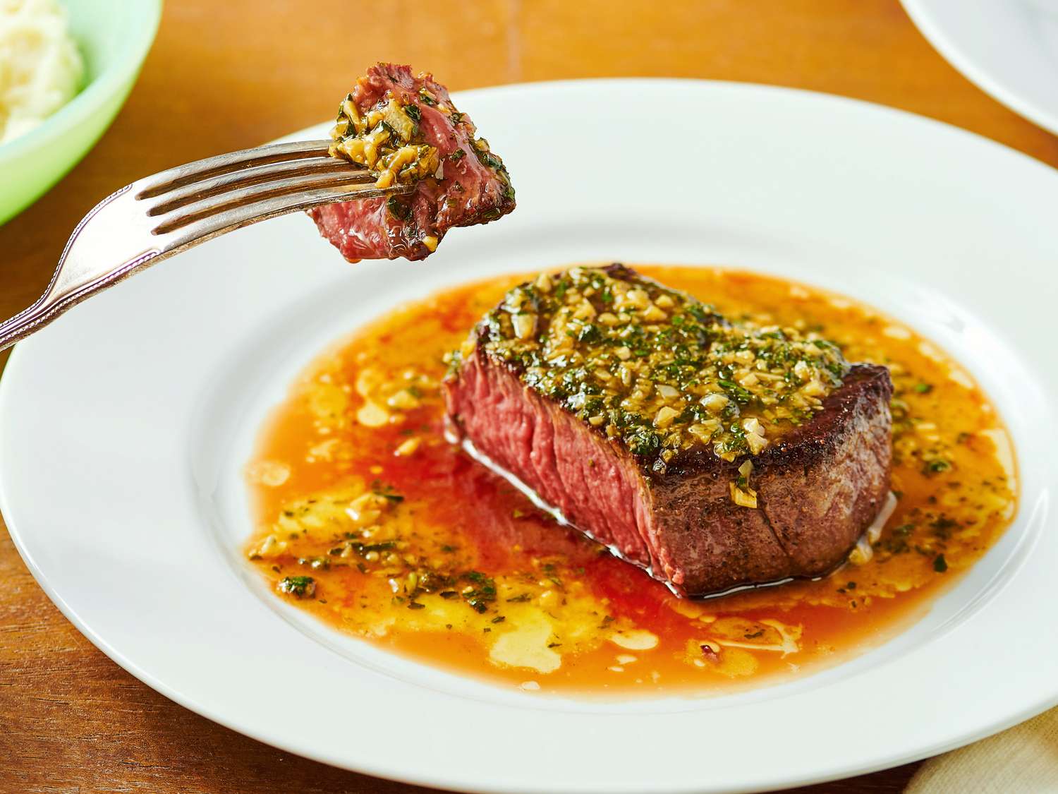 Steak DeBurgo dish on a plate with a piece held on a fork