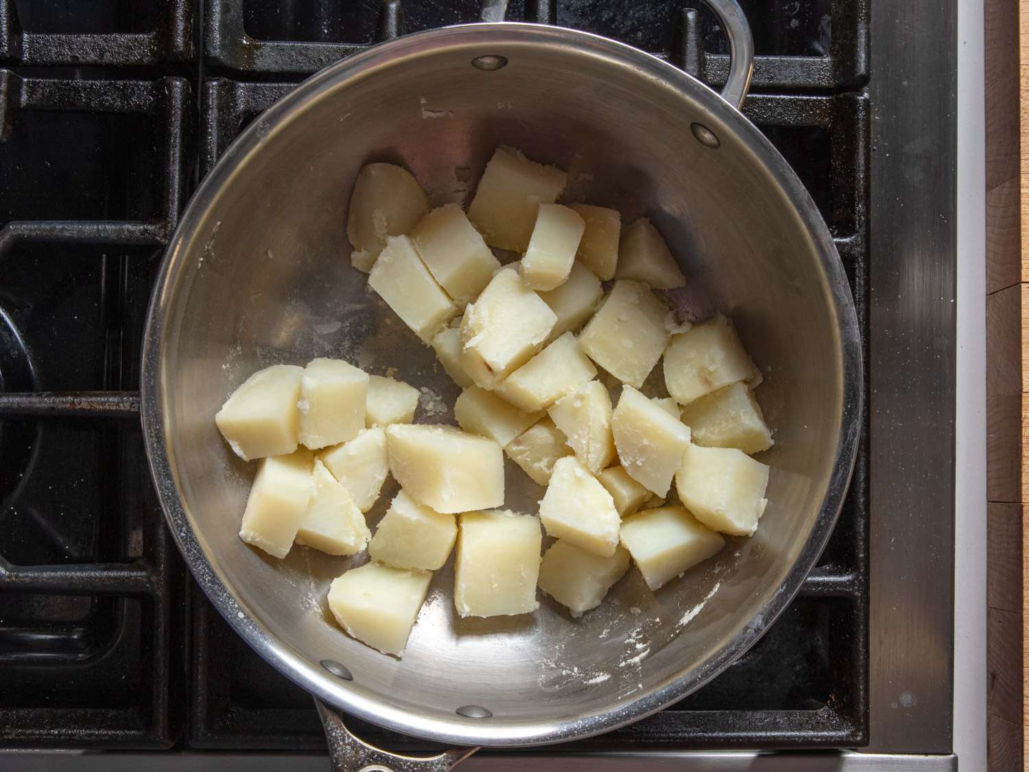 Drained boiled potatoes in a saucepan.