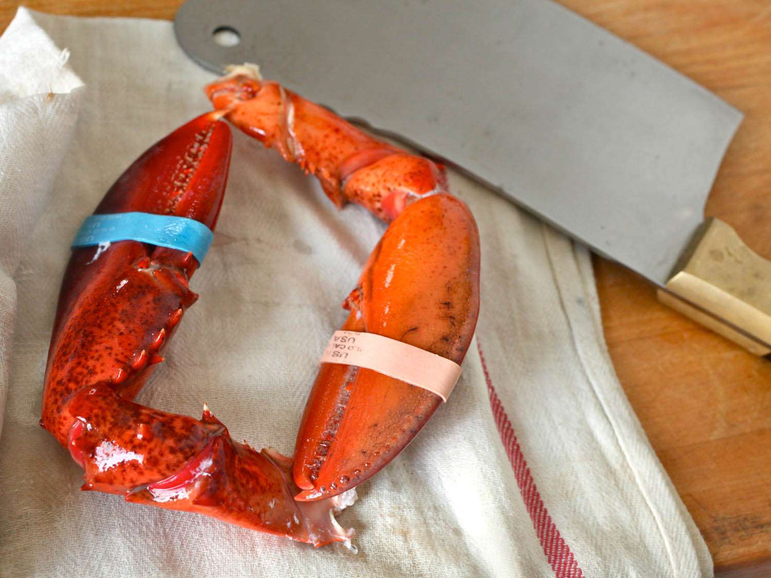 Cracking lobster claws with a cleaver.