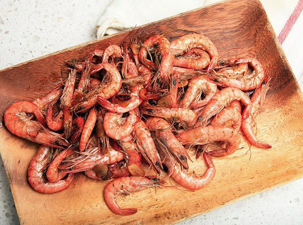 Camarao ao Alho on a wooden rectangular plate. 