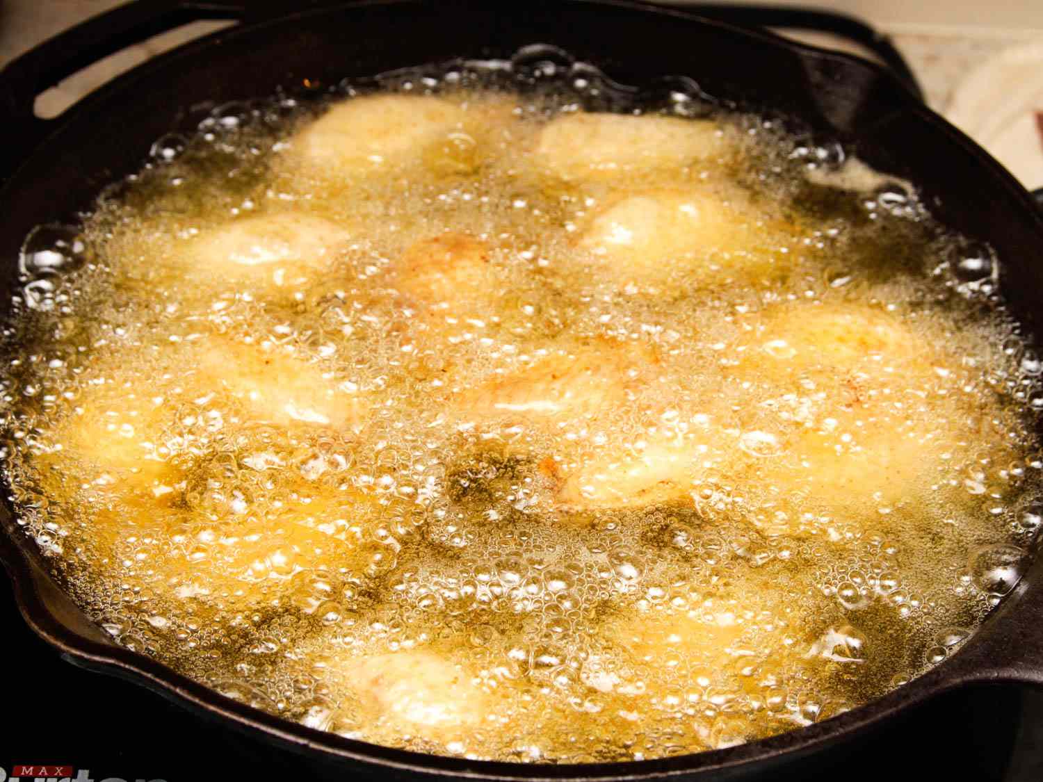 Deep-frying chicken wings in a cast iron skillet