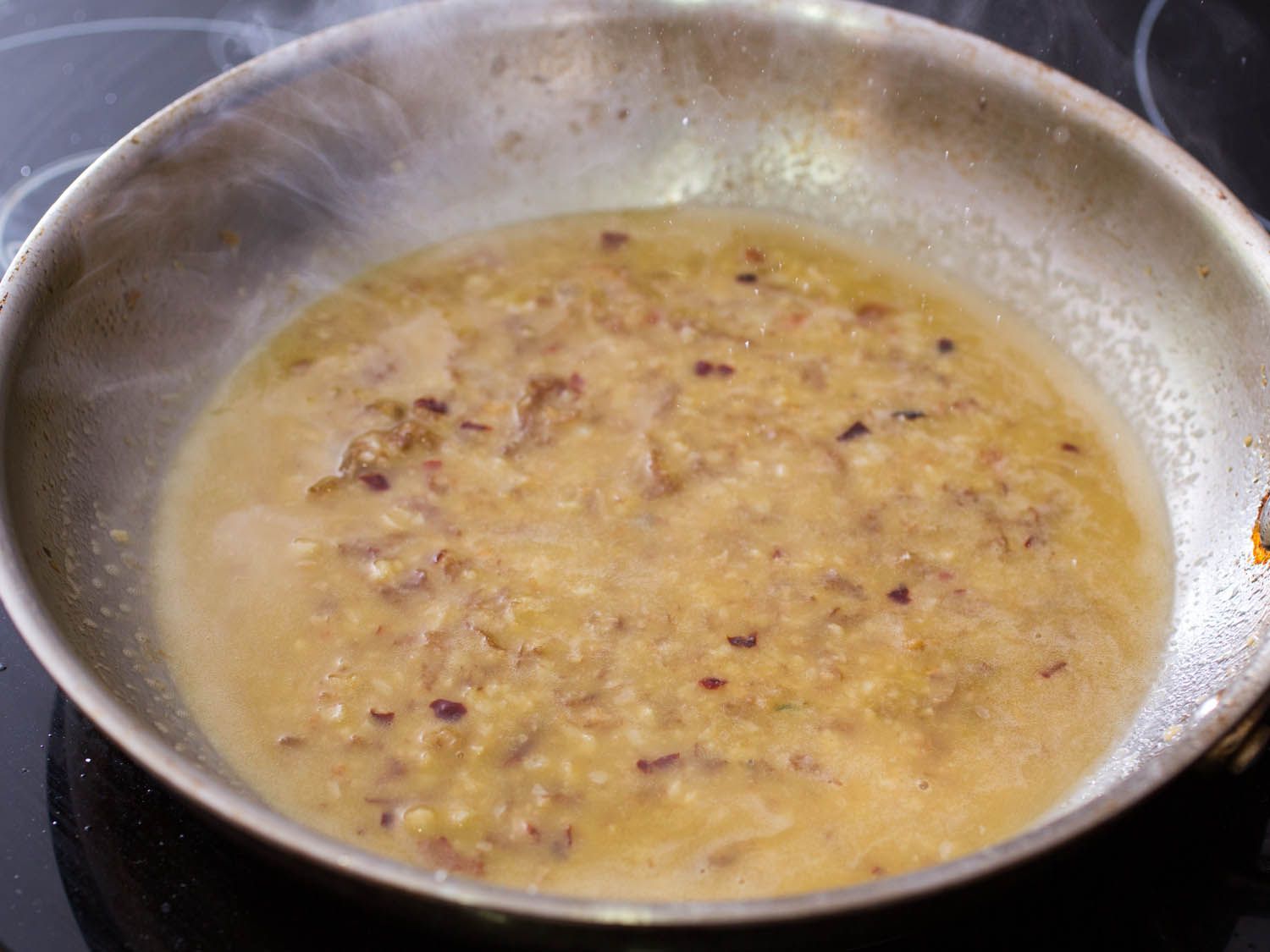 Emulsified garlic butter sauce in a stainless steel skillet.