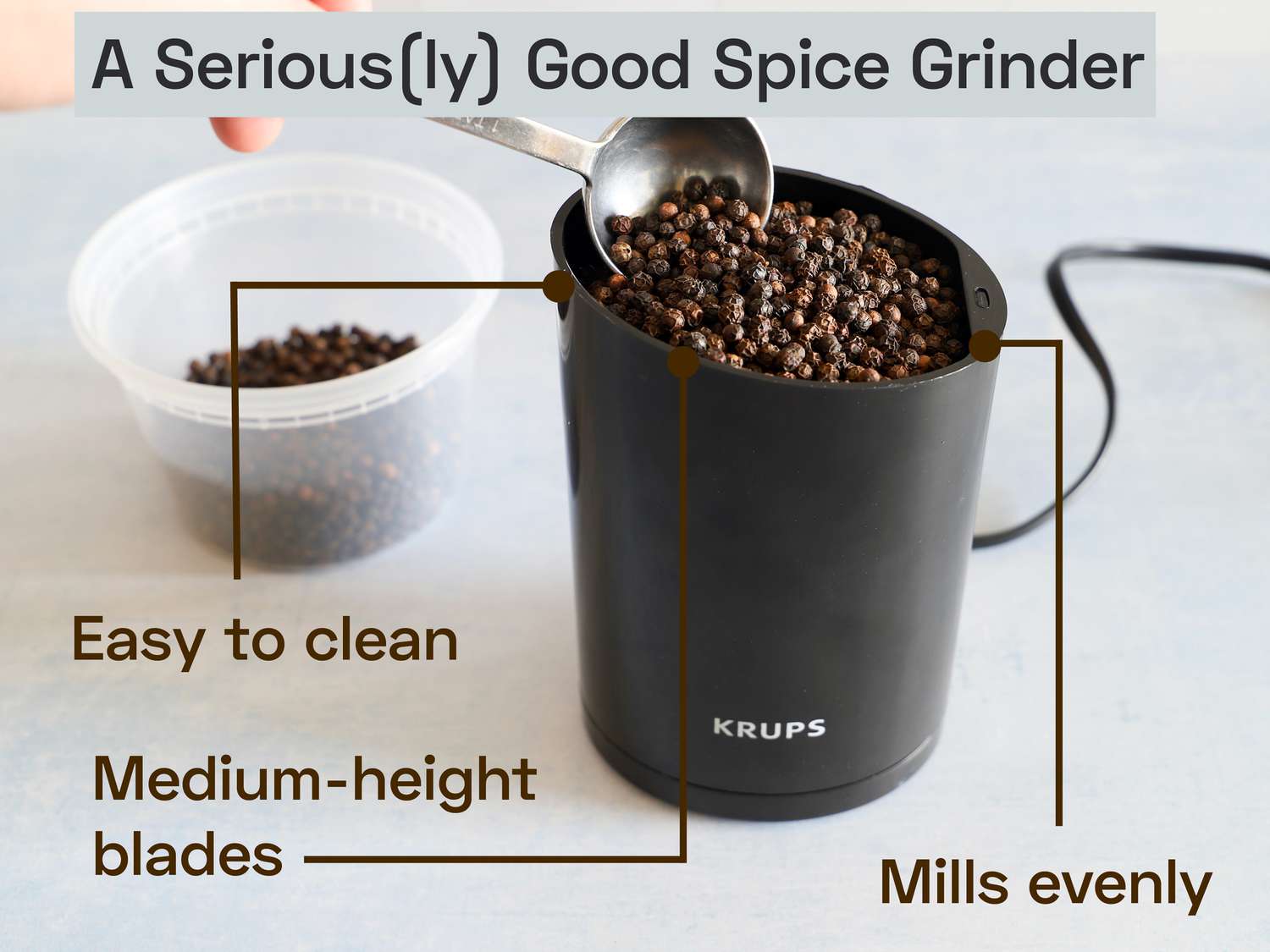the krups spice grinder with whole peppercorns being added to it