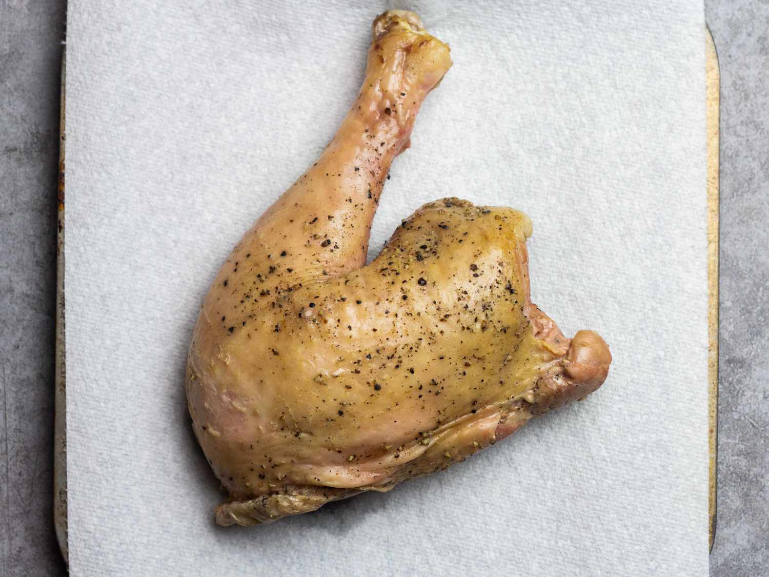 Sous vide turkey leg patted dry atop a paper towel-lined tray