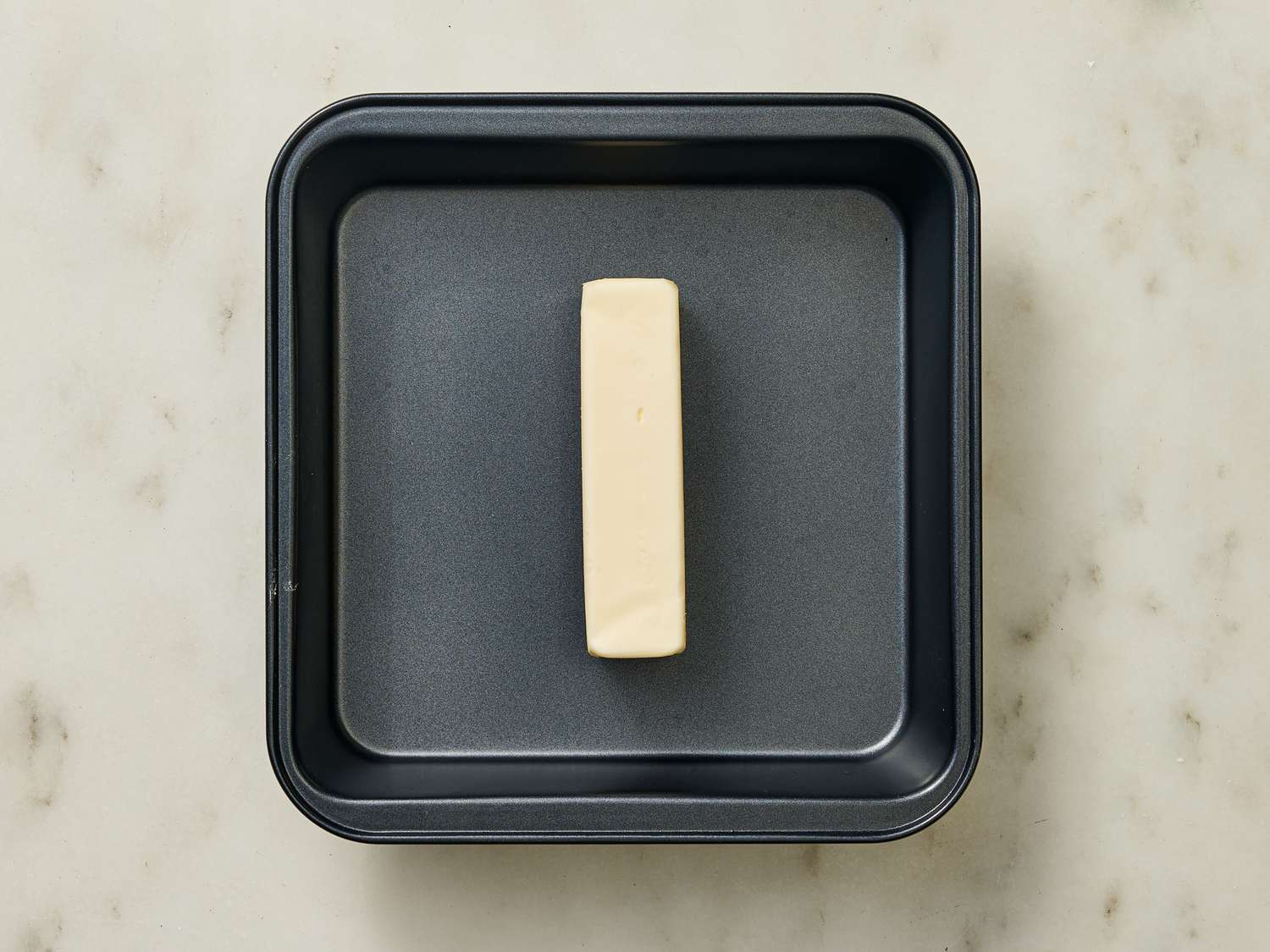 Stick of butter on a square baking dish 