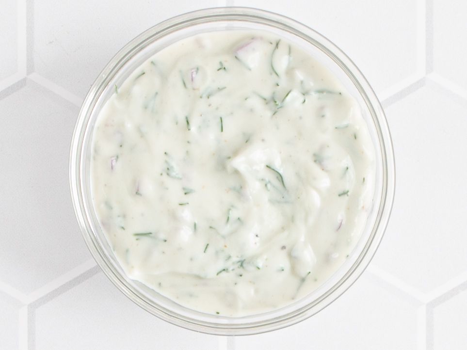  Yogurt, shallot, dill, lemon juice, olive oil, and ground coriander seeds stirred together in a glass bowl and seasoned with salt and pepper.