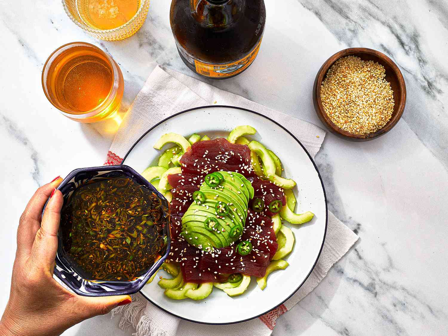 Overhead view of pouring sauce on sashimi 