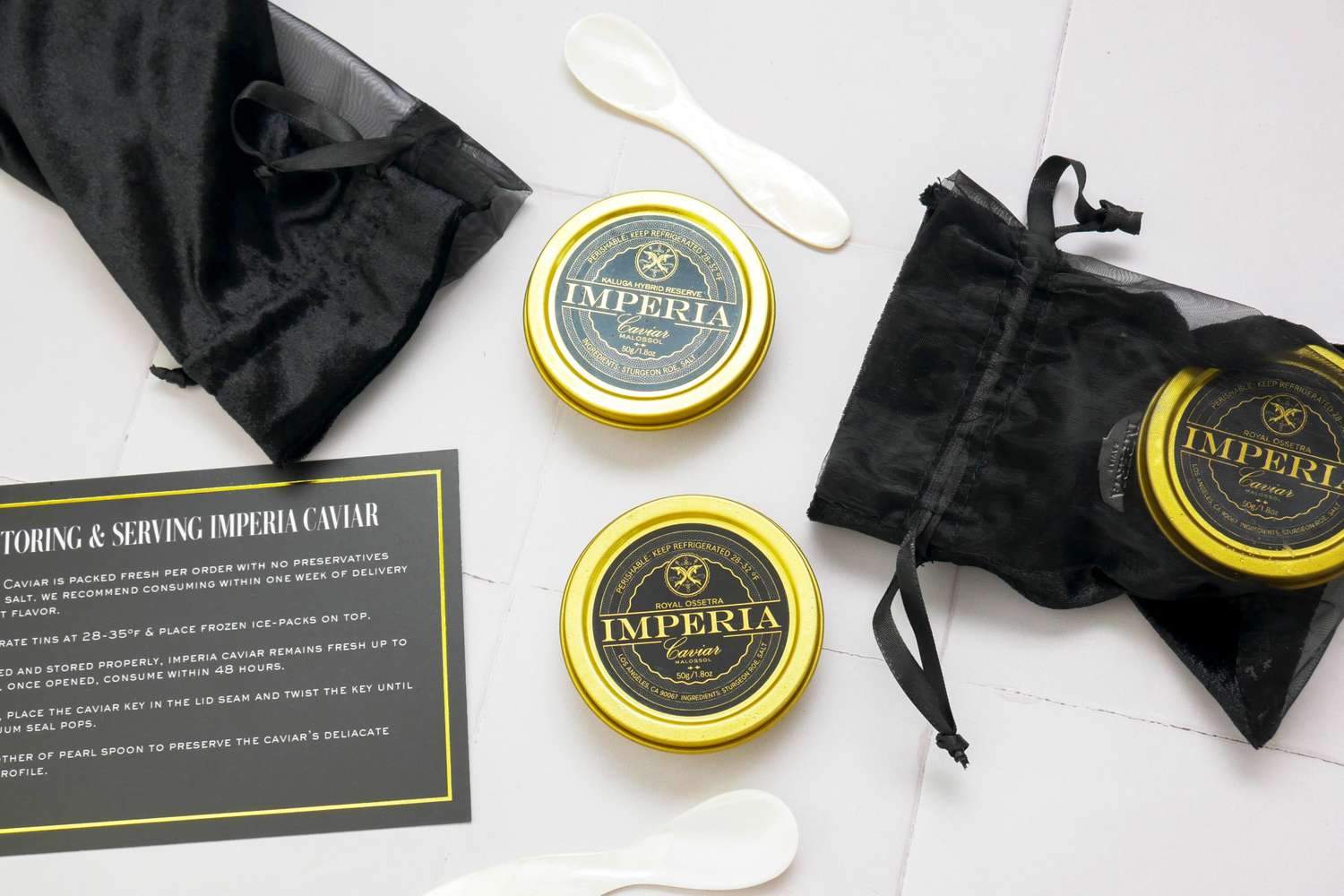 Imperia caviar tins with serving spoons and black pouches