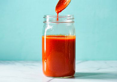 Finished sauce in a sealed glass jar with a spoon holding some of the mixture