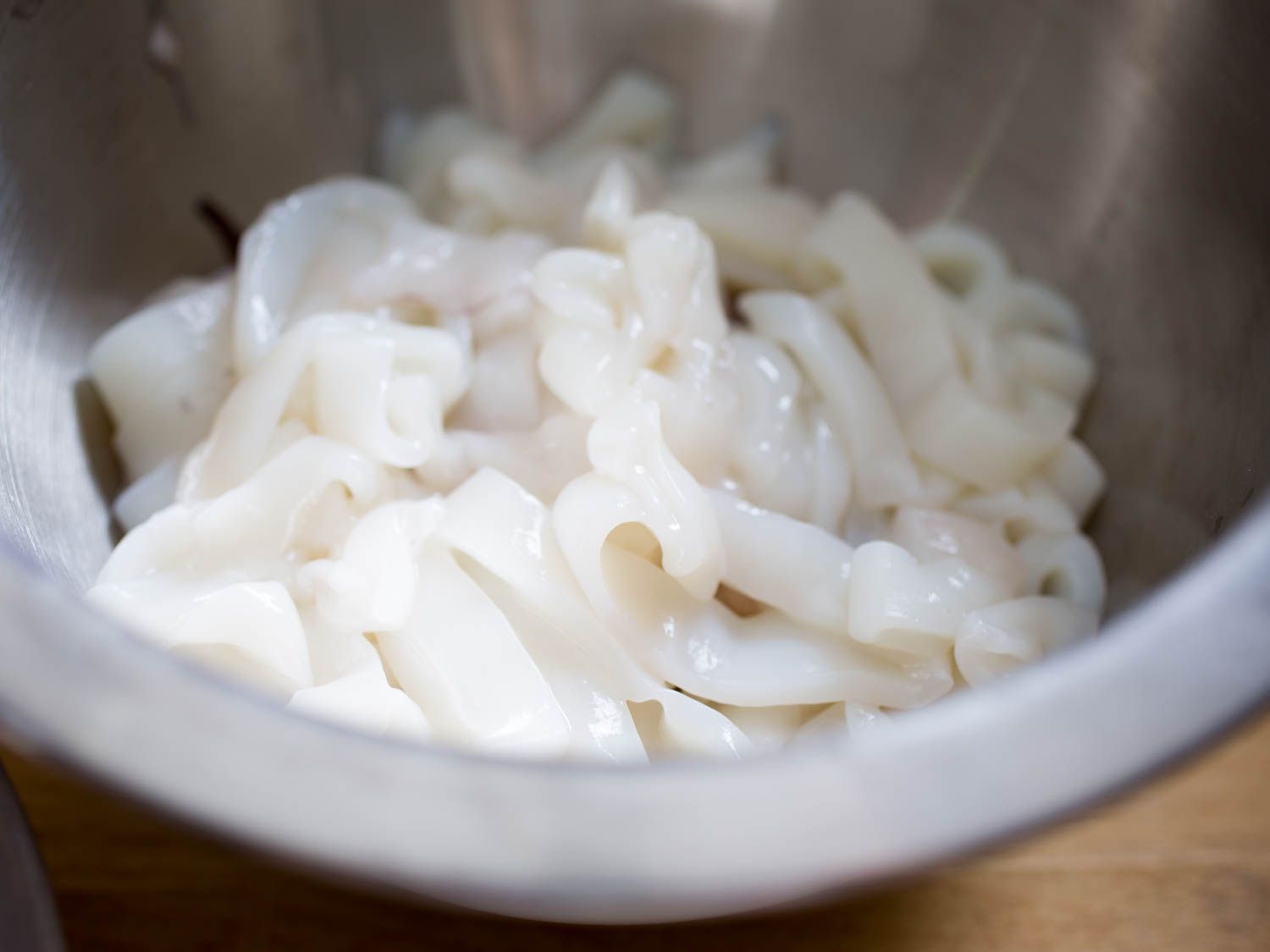 Cleaned raw squid, cut into rings in a mixing bowl.