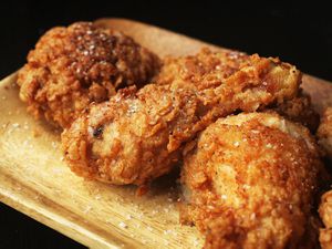 Fried chicken resting on a wooden platter