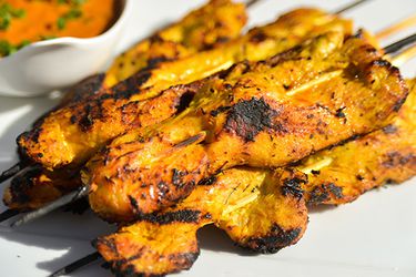 Chicken satay skewers resting on a plate