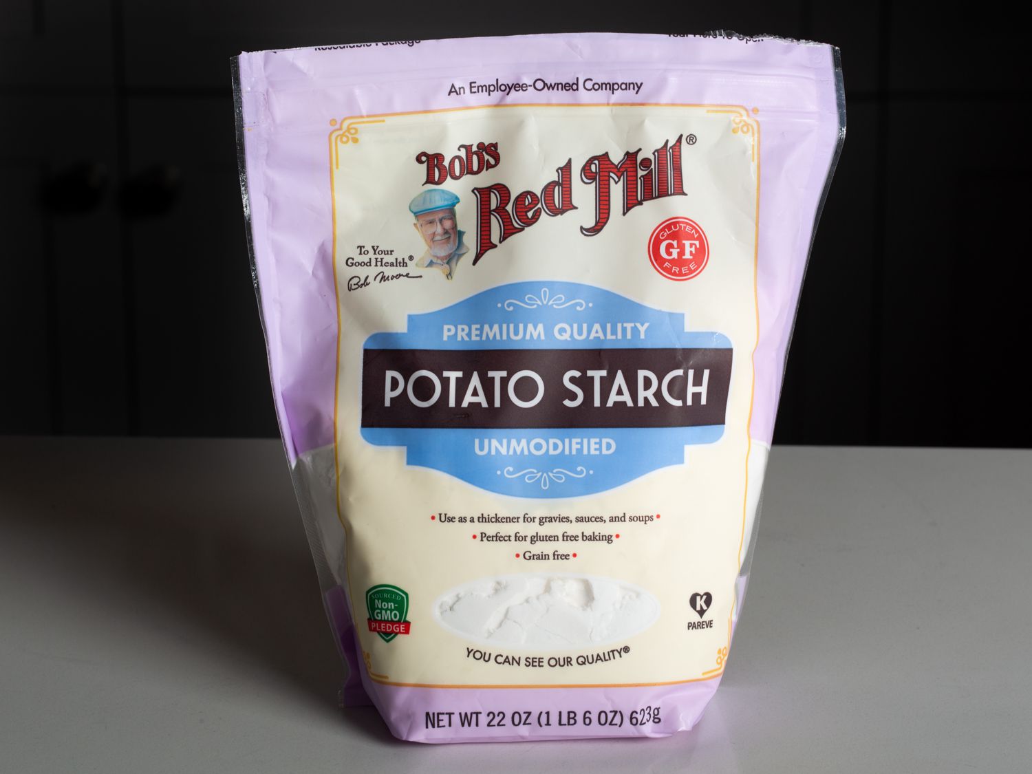 Bag of Bob's Red Mill Unmodified Potato Starch on a counter with a black background