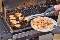 A person cooks wings in the Traeger Woodridge Pro