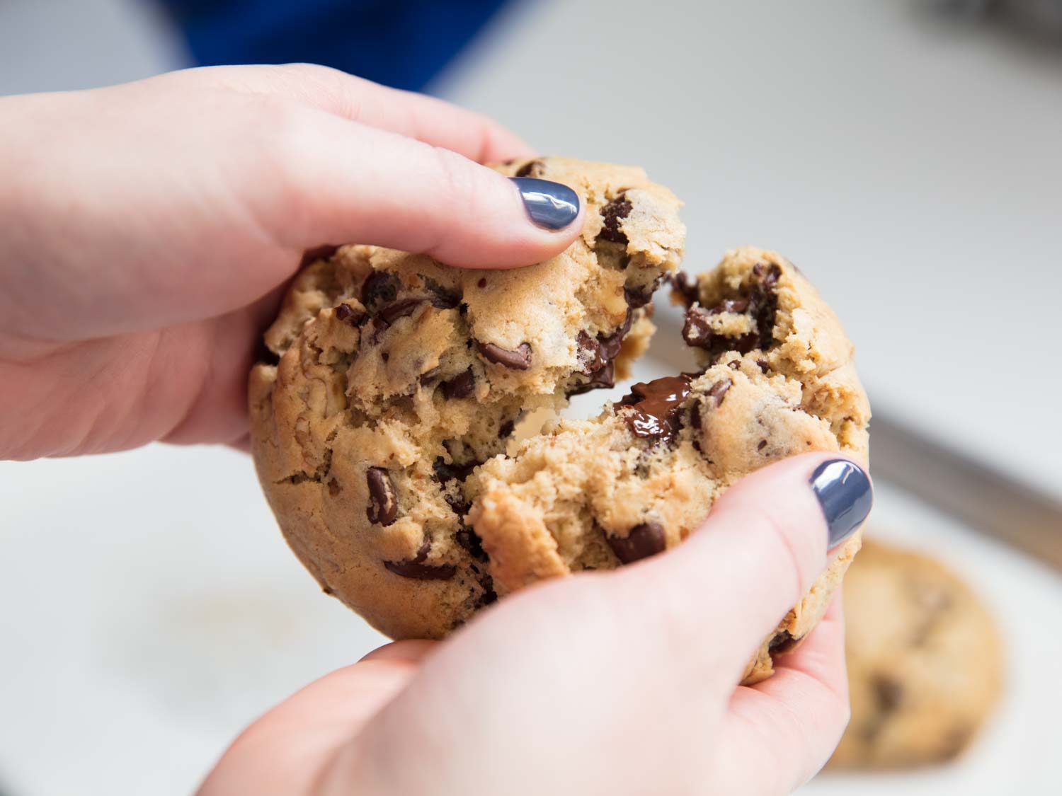 Breaking open a Levain Baker-style super thick chocolate chip cookie.