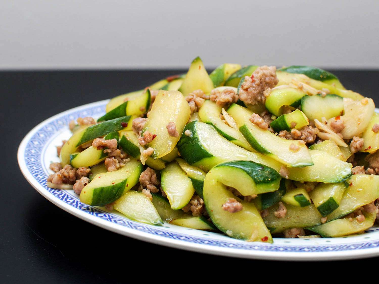 A close-up of the stir-fried cucumbers with spicy ground pork on a serving dish.