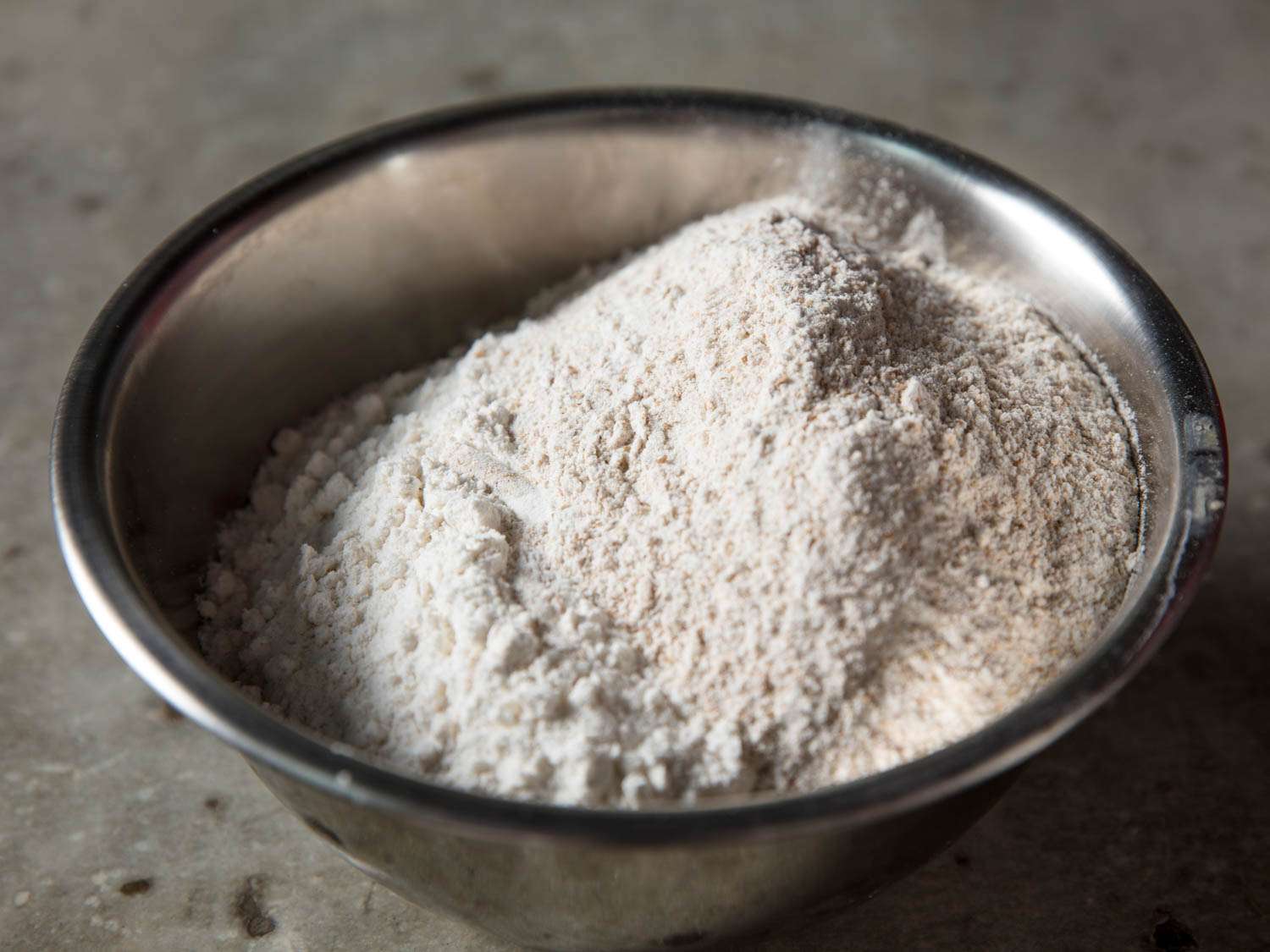 Whole wheat and all-purpose flours in a metal mixing bowl.
