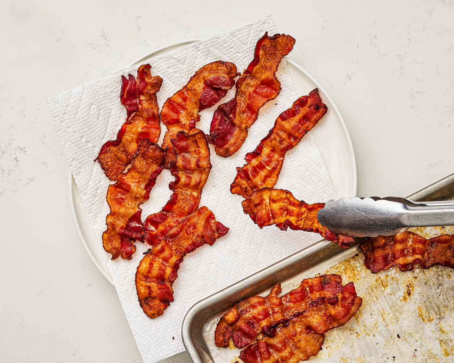 Overhead view of transferring bacon to a plate
