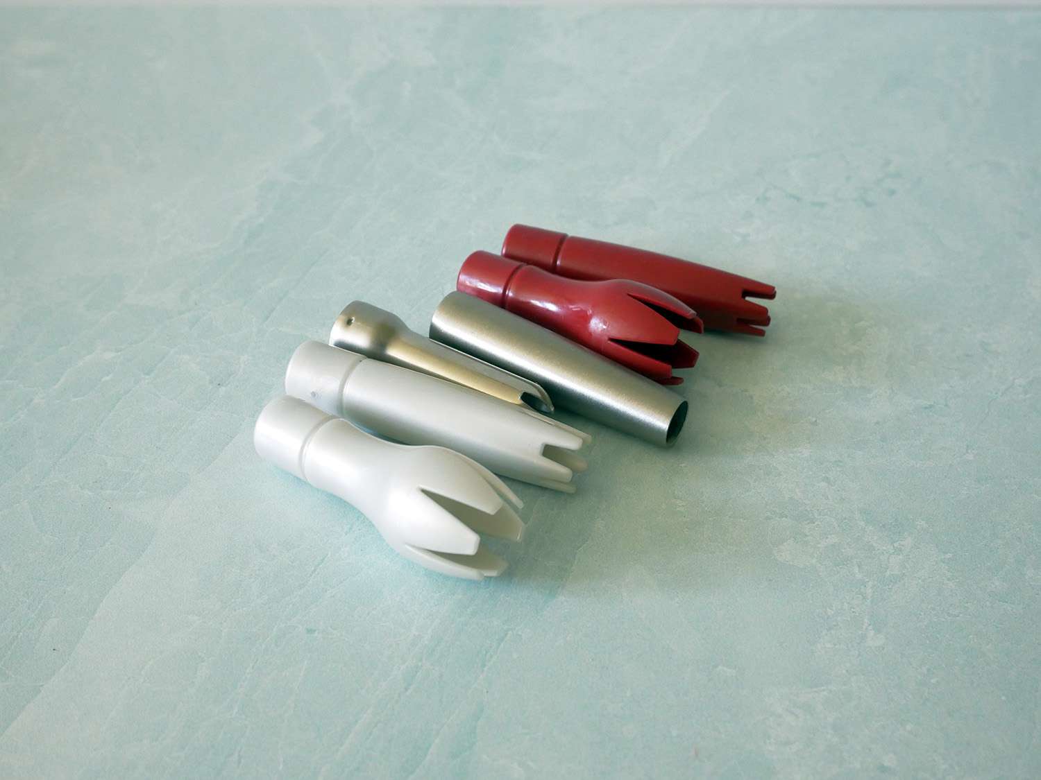 a variety of siphon tips on a sea foam green marble countertop.
