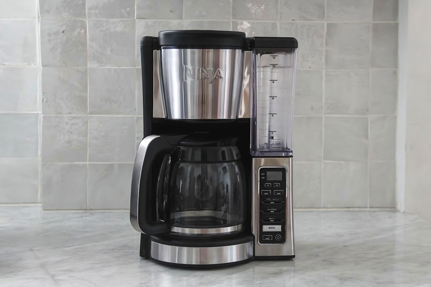 A Ninja CE251 12-Cup Coffee Brewer with a carafe, water reservoir, and control panel, displayed on a kitchen counter