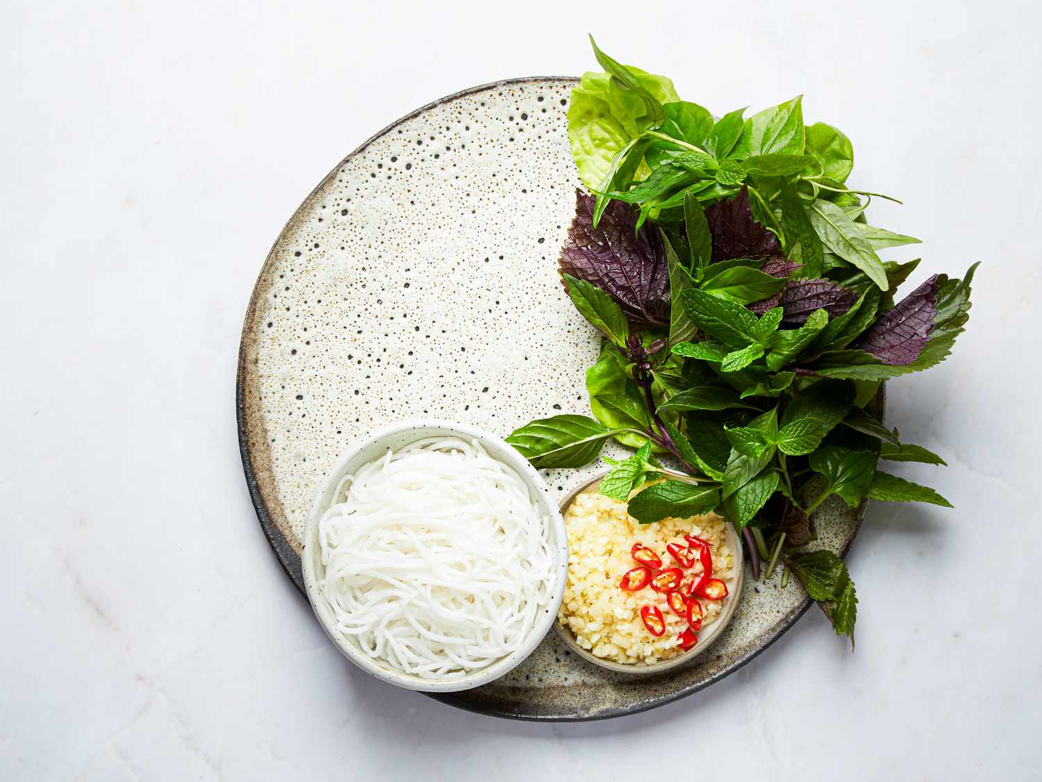 Overhead view of herbs and toppings on a plate