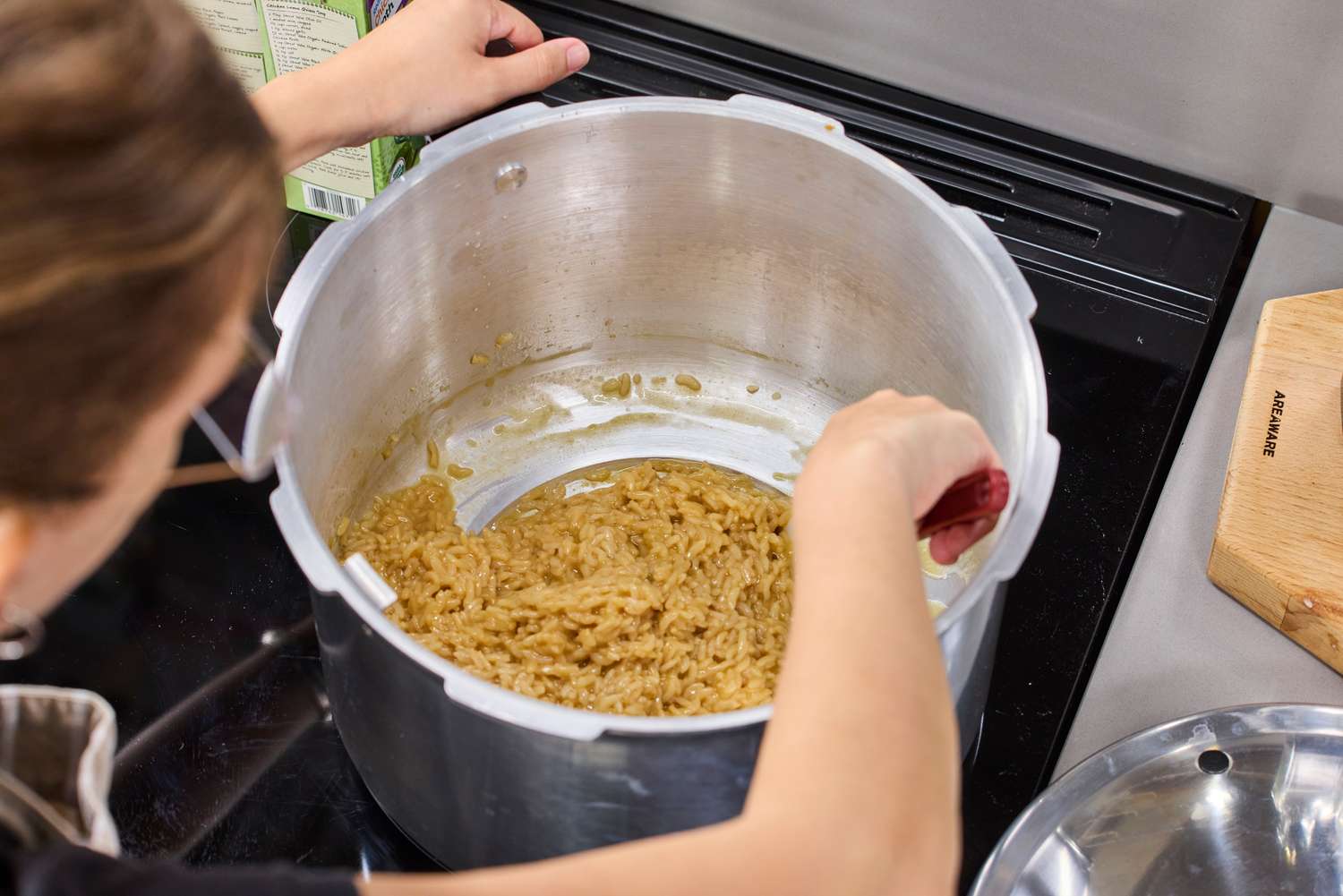 A person stirs risotto in the Presto 16-Quart Pressure Canner and Cooker